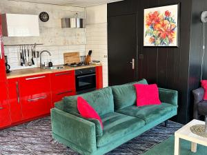 雷讷瑟Het Pronkje的红色橱柜厨房内的绿色沙发