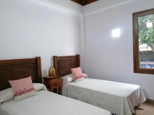 马佐Casa Amagante, en Hoyo de Mazo的配有2张床的白色墙壁和窗户。