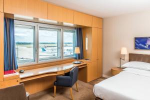 鲁瓦西昂法兰西Sheraton Paris Charles de Gaulle Airport Hotel的配有一张床、一张书桌和一扇窗户的酒店客房