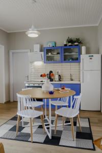 卡瓦拉Forget Me Not的厨房配有桌椅和蓝色橱柜。