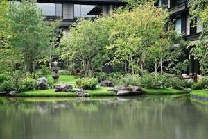京都HOTEL THE MITSUI KYOTO, a Luxury Collection Hotel & Spa的一座花园,在一座建筑前设有一个池塘