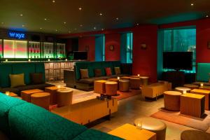 阿布扎比阿布扎比雅乐轩酒店的一间酒吧,配有沙发、椅子和电视