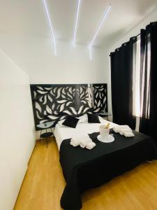 锡拉库扎Brimiky House的一间卧室配有一张带黑白床头板的床