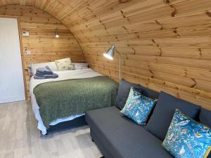 邓甘嫩Orchard Luxe Glamping Pod的一间卧室配有一张床和一个沙发