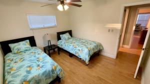 克利尔沃特Delightful 3 Bdrm Home, Mins to Clearwater Beach的一间卧室配有两张床和吊扇