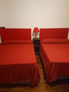 图蓬加托火山Mirador de Estrellas的两张红色的床,彼此相邻,位于房间
