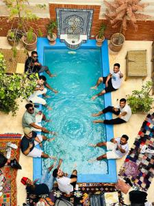 马拉喀什46号摩洛哥传统庭院住宅的一群人坐在游泳池周围