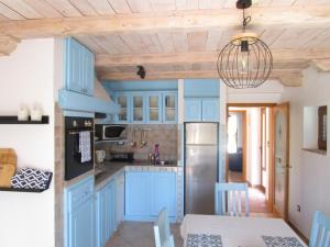 波雷奇Casa Vežnaveri的厨房配有蓝色橱柜和餐桌
