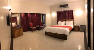 卡拉奇Hotel Inn Karachi的酒店客房带一张床、一张桌子和椅子