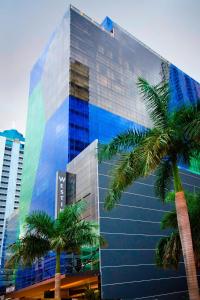 巴拿马城巴拿马威斯汀酒店的一座高大的玻璃建筑,前面有棕榈树