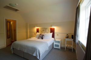 切斯特The Egerton Arms的卧室配有一张大白色床和窗户
