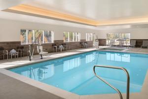 洛根TownePlace Suites by Marriott Logan的一座配有桌椅的酒店游泳池