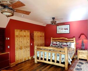 CameronDream Drift Motel的卧室设有红色的墙壁和木床。