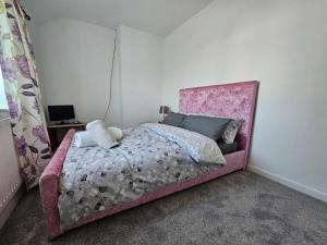 提伯利Mo's home的卧室内的一张带粉红色床头板的床