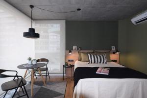 蒙得维的亚Diseño con vistas al Parque y Mar Punta Carretas的卧室配有一张床和一张桌子及椅子