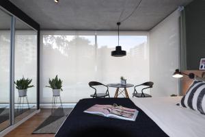 蒙得维的亚Diseño con vistas al Parque y Mar Punta Carretas的卧室配有一张床和一张桌子及椅子