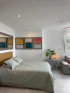 马拉加Allegra Suite的卧室配有一张床,墙上挂有四幅画作