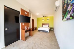 圣克鲁斯华特库Villas Coral Huatulco的一间卧室配有一张床和一台平面电视