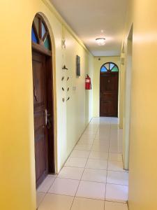 桑给巴尔Garden Lodge的一条空的走廊,有门,铺着瓷砖地板