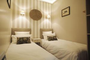 巴黎圣日耳曼优雅奇客修特斯公寓的配有白色床单的客房内的两张床