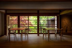 白川村施洛亚玛坎日式旅馆的带窗户的客房内配有2张桌子和椅子