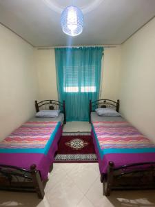 丹吉尔Appartement kenzi Beach的小型客房 - 带2张床和窗户