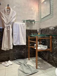 艾西拉Prestigieux Appartement à Marina Assilah Golf的浴室配有盥洗盆、镜子和毛巾
