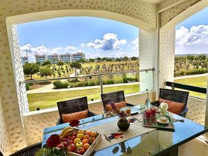 艾西拉Prestigieux Appartement à Marina Assilah Golf的阳台上的桌子上放着一碗水果