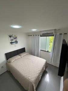 盖比姆Apartamento na Praia de Guaibim的白色的卧室设有床和窗户