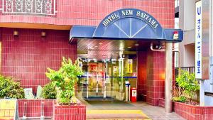 埼玉市埼玉新酒店的一间有蓝色入口的红砖建筑前的商店