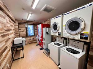 埼玉市埼玉新酒店的洗衣房配有洗衣机、洗衣机和烘干机