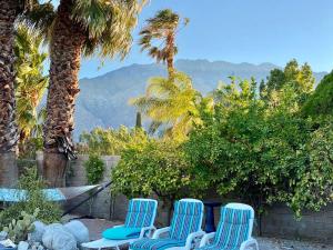 棕榈泉Dreamy Palm Springs Villa w Pool, Spa, Great Views的三个蓝色椅子坐在棕榈树庭院里