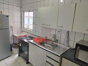 伊塔佩马APT Praia Central Itapema 90MTS do Mar的一间带水槽和炉灶的小厨房