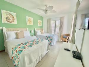 El LimónStunning Beachfront Condo With Private Beach, Las Terrenas-el Limn的酒店客房设有两张床和一张桌子。