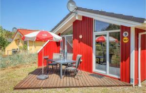 特拉弗明德Schatzkiste 9 - Dorf 4的红色的房子,配有桌子和雨伞