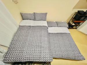 伊洛伊洛* * * E Best Value Room for up to 3的一张带黑白棉被和枕头的床