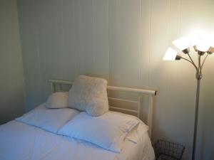 HonorSleeping Bear Riverside Cabins - Cabin #4的一张带两个枕头的床,靠在灯边