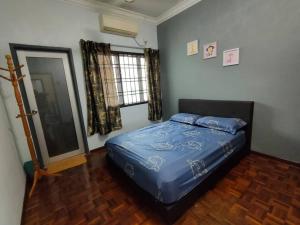 马西Happy Home [Bandar Seri Alam]的一间卧室设有蓝色的床和窗户。