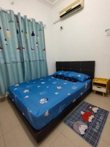 马西Happy Home [Bandar Seri Alam]的一间卧室配有一张带蓝色棉被的床