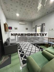 巴力文打Nipah Homestay Parit Buntar的客厅墙上挂着 ⁇ 的寄宿标志