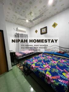 巴力文打Nipah Homestay Parit Buntar的墙上有标牌的房间的一张床位