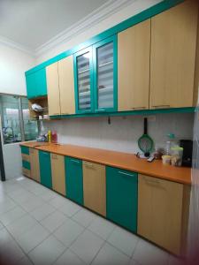 马西Happy Home [Bandar Seri Alam]的厨房配有蓝色和绿色的橱柜