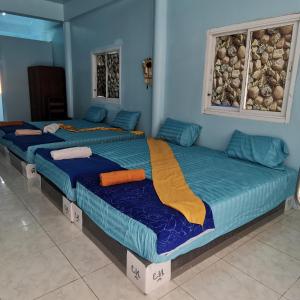 哈林海滩Haadrin village Fullmoon的蓝色墙壁的客房内的三张床