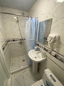 撒马尔罕OLD STREET Guest House的白色的浴室设有水槽和镜子