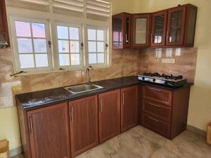 尼甘布Cross Ceylon的一个带木制橱柜和水槽的厨房