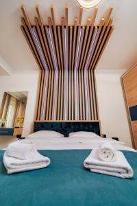 北马马亚-讷沃达里NorthBay Sunrise View - Infinity Pool & Spa Resort的一间卧室配有一张大床和两条毛巾