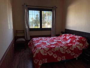 库奇拉阿尔塔Casa Alquiler Cuchilla Alta 1的卧室配有红色和白色的床,设有窗户
