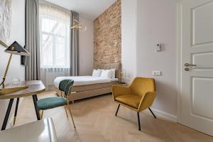 维尔纽斯St Casimir Apartments的配有一张床和一把椅子的酒店客房