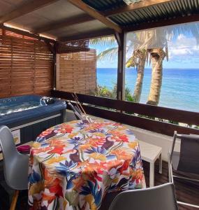 圣安德烈Les îlots du soleil levant的客房设有桌子和海洋浴缸。