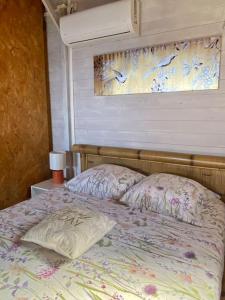 圣安德烈Les îlots du soleil levant的一间卧室配有一张带鲜花棉被的床